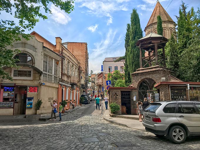 Georgia-Tbilisi-Old-Town-street-scene-with-Jvaris-Mama-Chruch-tower.jpg